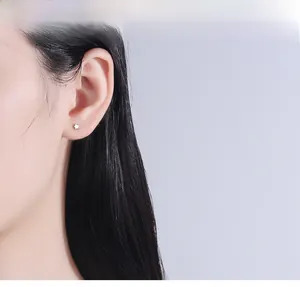 Close-up of minimalist tiny silver star stud earring worn on the earlobe for women