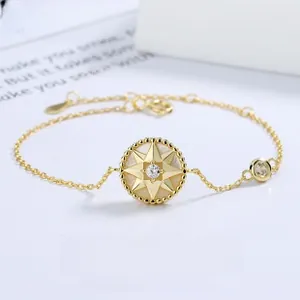 Détail du bracelet boussole en or avec nacre blanche et zircon brillant serti