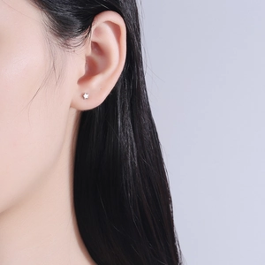 Minimalist S925 sterling silver star stud earring worn on earlobe for women