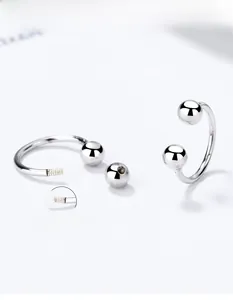 Macro detail of 925 silver U-shape screw stud earrings with ball ends on white background