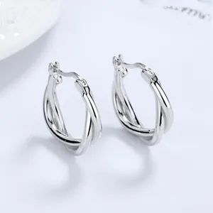 Macro detail of high-polish 925 sterling silver hoop earrings with twisted double-ring texture