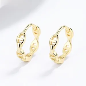 Vue macro de boucles d'oreilles dorées maillons nez de porc serties de cristaux