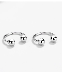 Macro view of polished 925 sterling silver U-shaped horseshoe earrings with round beads