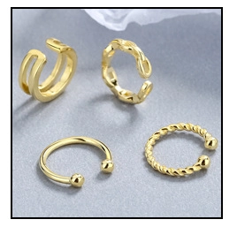 Detail von vierteiligem vergoldetem Ohrringset mit gedrehten und glatten Kettenstrukturen
