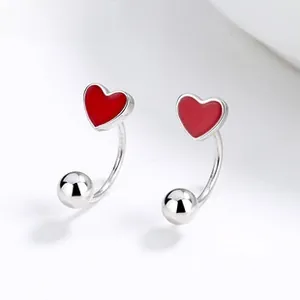 Macro shot of 925 sterling silver U-shaped stud earrings with red enamel hearts