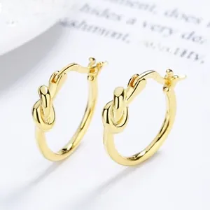 Macro shot of S925 sterling silver knot hoop earrings with golden finish and hallmark
