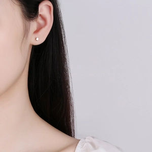 Minimalist square geometric silver cube stud earrings shown on ear for modern styling