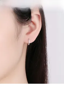 Vue macro de boucles d'oreilles créoles en argent massif avec pavé de zircons brillants