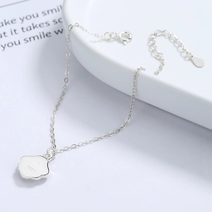 925 sterling silver ginkgo leaf bracelet with white mother-of-pearl charm on ceramic tray