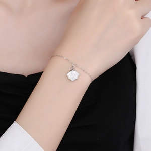 Elegant 925 sterling silver ginkgo leaf bracelet with white mother-of-pearl charm on wrist