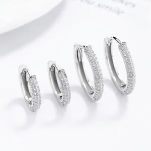 Vue macro détaillée des boucles d'oreilles huggie en argent 925 avec pavé de zircons cubiques