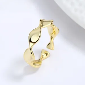 Close-up of golden wavy twisted open ring with a polished finish and adjustable band