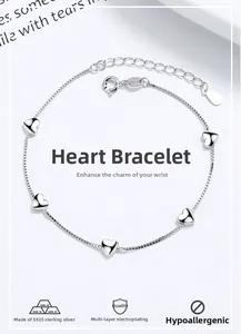 Macro shot of 925 sterling silver box chain bracelet with five polished heart charms