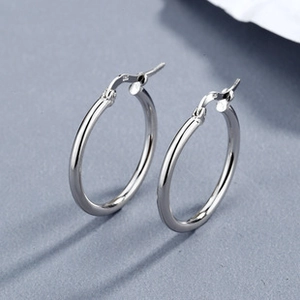 Macro shot of S925 sterling silver hoop earring detailing the hallmark and polished finish