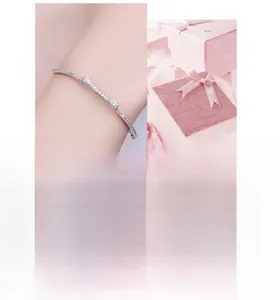 Close-up of bow knot silver bracelet with sparkling zircon inlay and pink gift box packaging