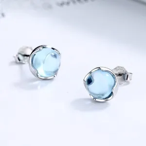 Macro shot of 925 silver stud earrings featuring round light blue gemstone spheres