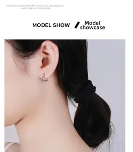Gros plan d'une boucle d'oreille cœur en argent S925 sur modèle montrant le confort du bijou