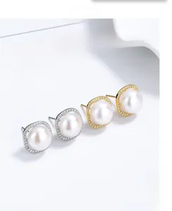 Detail of S925 silver pearl earrings with cubic zirconia square frames in silver and gold