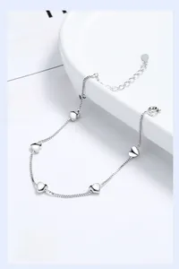 Detail of 925 sterling silver box chain bracelet with five polished heart-shaped pendants