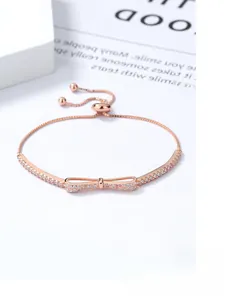 Detail of rose gold bow bracelet with white zircons and adjustable pull chain clasp