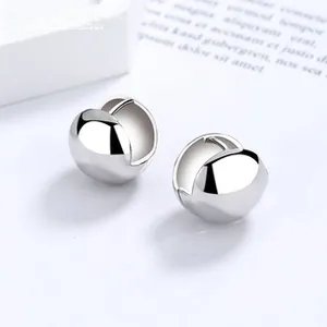 Macro view of polished silver ball earrings with high gloss finish on white background