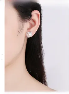 Detail of s925 silver stud earring with natural freshwater pearl and crystal frame on ear