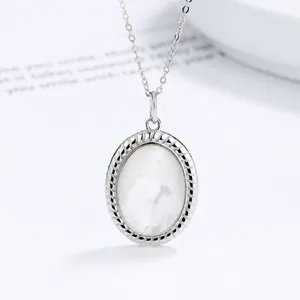 Close-up of a 925 sterling silver oval pendant necklace featuring a white pearl inlay