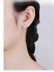 Close-up of 925 sterling silver geometric spike hoop earrings worn by a model
