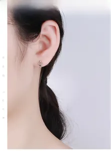 Gros plan de boucles d'oreilles couronne en argent S925 avec zircon portées par un mannequin
