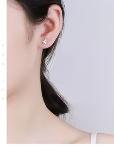Close-up of 925 sterling silver maple leaf stud earring worn by a model on the ear