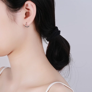 Boucles d'oreilles créoles cœur en argent 925 portées par un mannequin femme de face