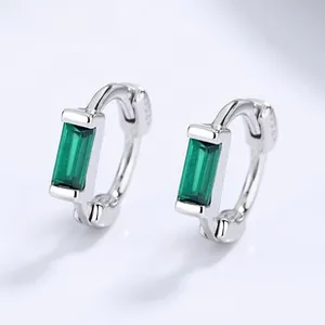 Macro view of S925 sterling silver hoop earrings with rectangular emerald green stones