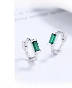 Macro detail of silver rectangle earrings with emerald green cubic zirconia stones