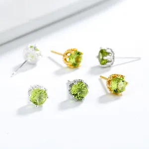 Detail of 925 sterling silver crown earrings with green gemstones in gold and silver finish