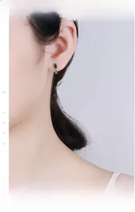 Close-up of 925 sterling silver hoop earring with rectangular emerald green zircon