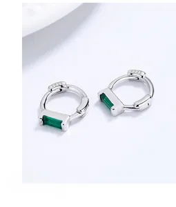 Macro shot of S925 sterling silver stamp and emerald-cut green cubic zirconia earrings