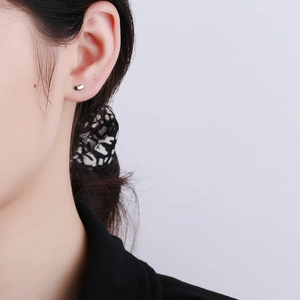 Puce d'oreille haricot minimaliste en argent 925 portée pour un look délicat et fin