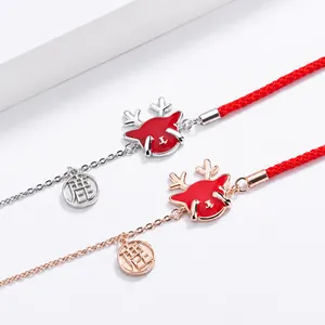 Detalle de pulseras de ciervo en esmalte rojo con cordón en plata y oro rosa