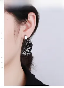 Close-up model view of geometric 925 sterling silver rectangular hoop earrings in silver
