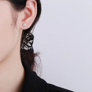 Daisy flower earrings in 925 sterling silver with yellow core on female model ear