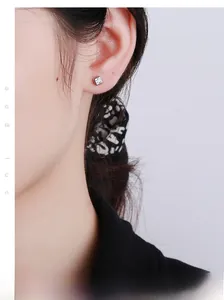 Macro detail of minimalist S925 silver stud earring with square cubic zirconia on ear