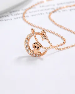 Detalle en primer plano del colgante de perro del zodiaco en oro rosa con luna y circonitas