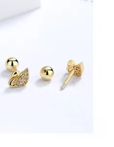 Detail of gold swan stud earrings with screw-back design and zircon inlay for women
