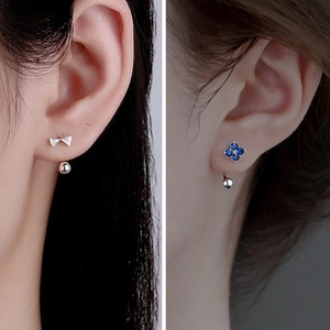 Detaillierte Nahaufnahme von S925-Silberohrringen mit Schleifen- und blauem Kleeblatt-Design