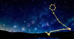 Detail view of gold Leo constellation pendant featuring stars over a starry night sky background