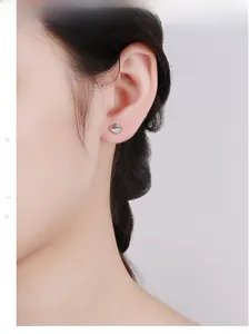 Macro detail of 925 sterling silver swan stud earrings with cubic zirconia on model