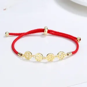 Adjustable red braided rope bracelet with four golden hollow lucky charms and smooth metallic beads