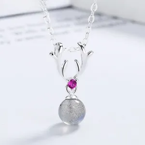 Macro shot of silver antler pendant with lavender gem and round labradorite stone detail