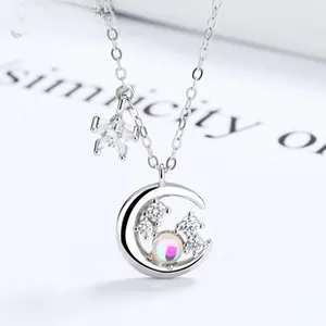 Macro shot of S925 silver moon and star necklace with shimmering opal and pavé diamonds