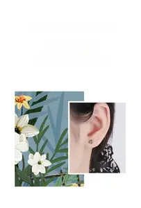 Detail of silver sunflower stud earrings with black center and minimalist design